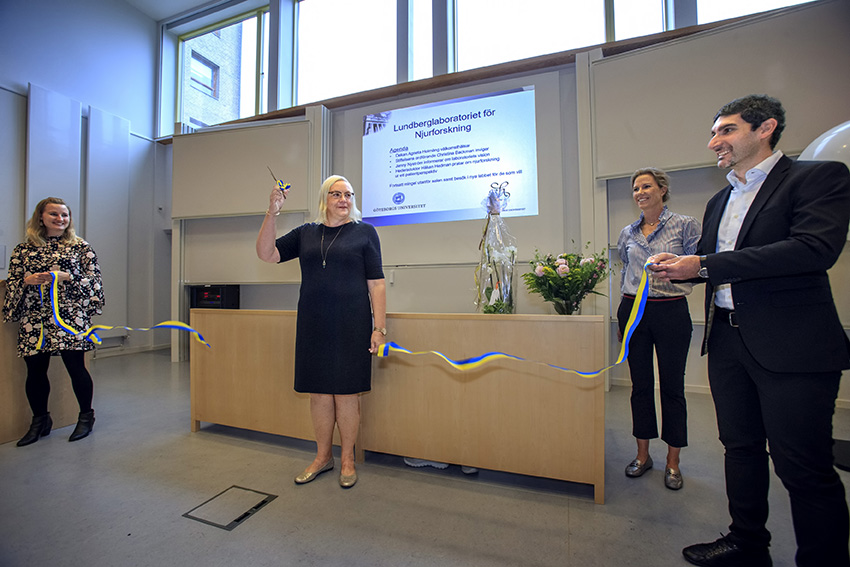 Christina Backman, chairman of the board, cuts the ribbon